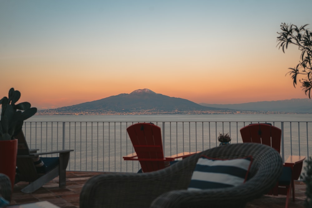 a patio with chairs and a view of the ocean