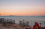 An outdoor terrace with elegant seating overlooking a beautiful sunset.