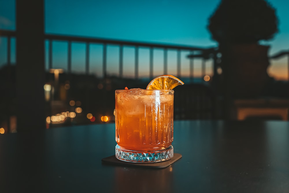 a drink with a slice of lemon sitting on a table