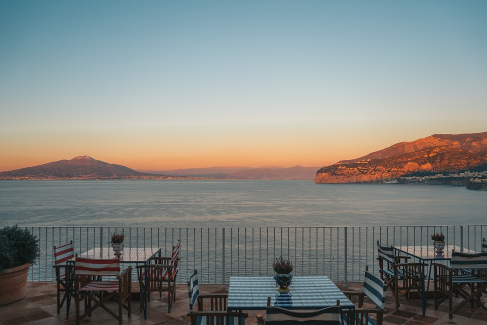 a table and chairs with a view of the ocean