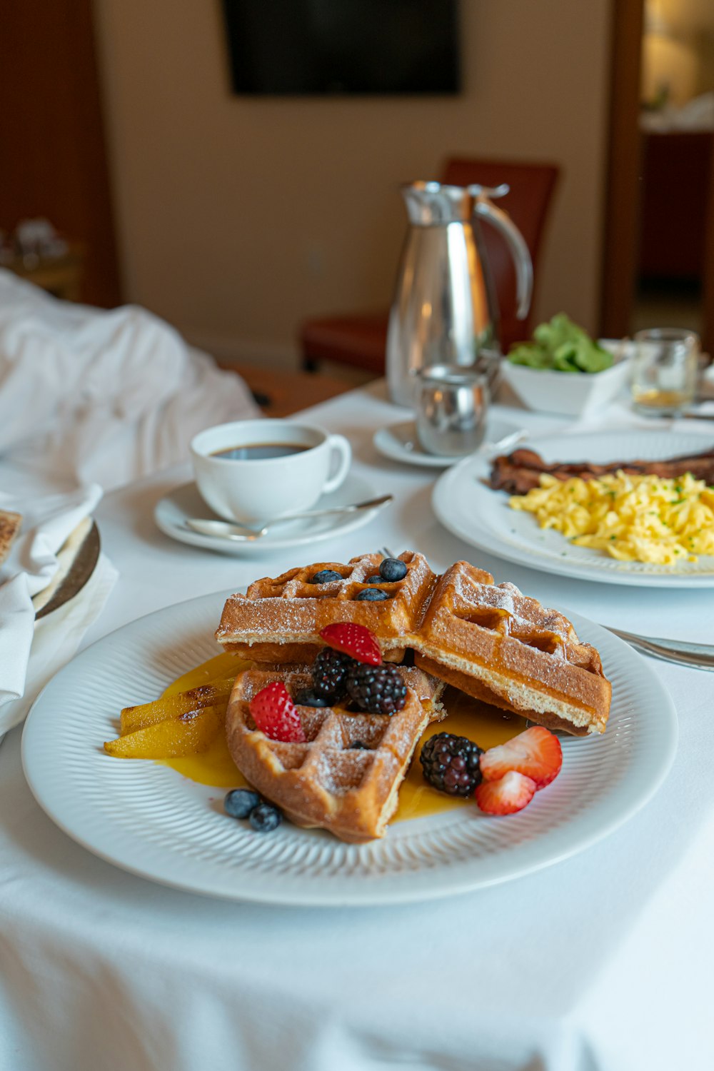 a plate of waffles and fruit on a table