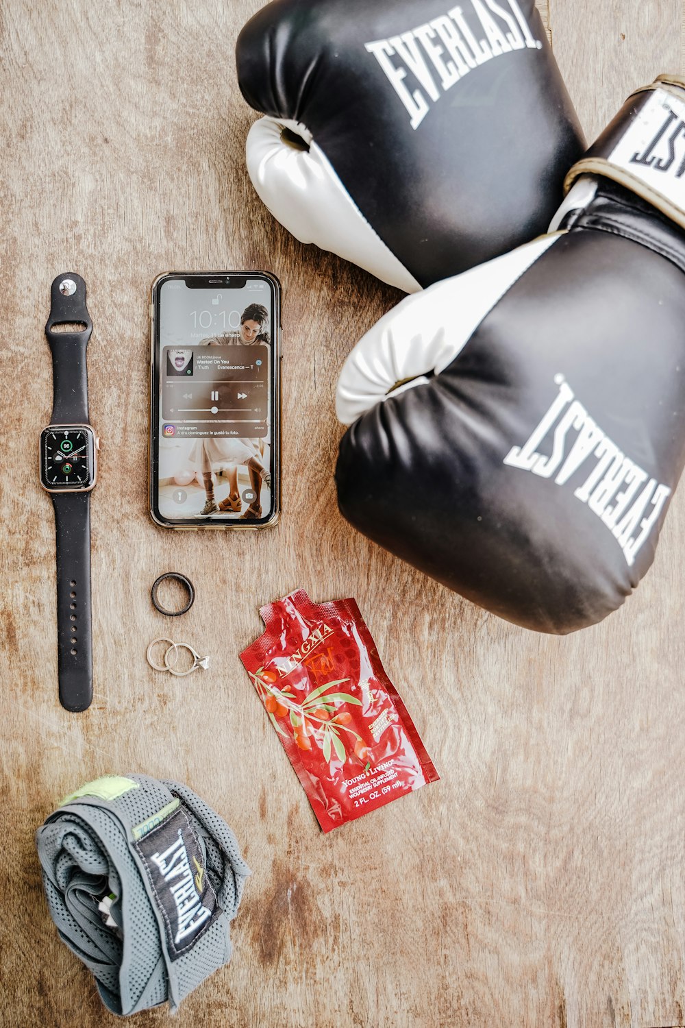 a wooden table topped with boxing gloves and a smart phone