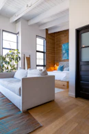 a white couch sitting in a living room on top of a hard wood floor