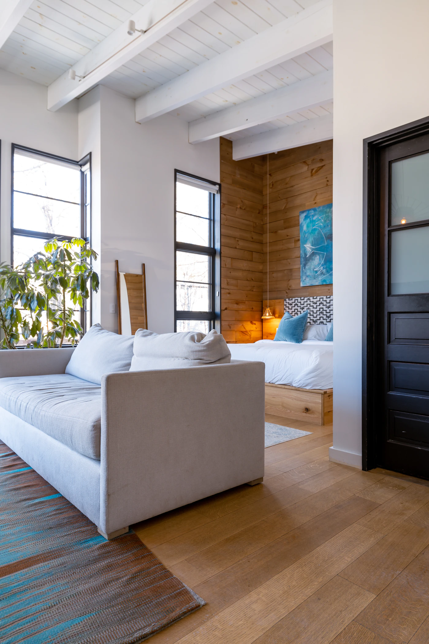 Bright interior with a white sofa and natural hardwood floor