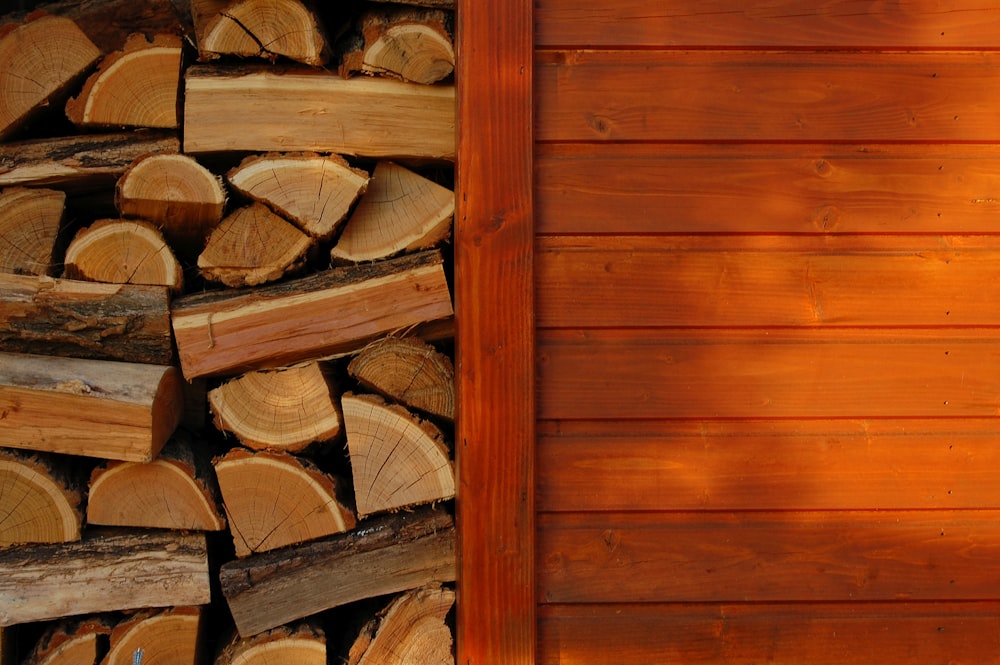 a pile of wood sitting next to a wooden wall