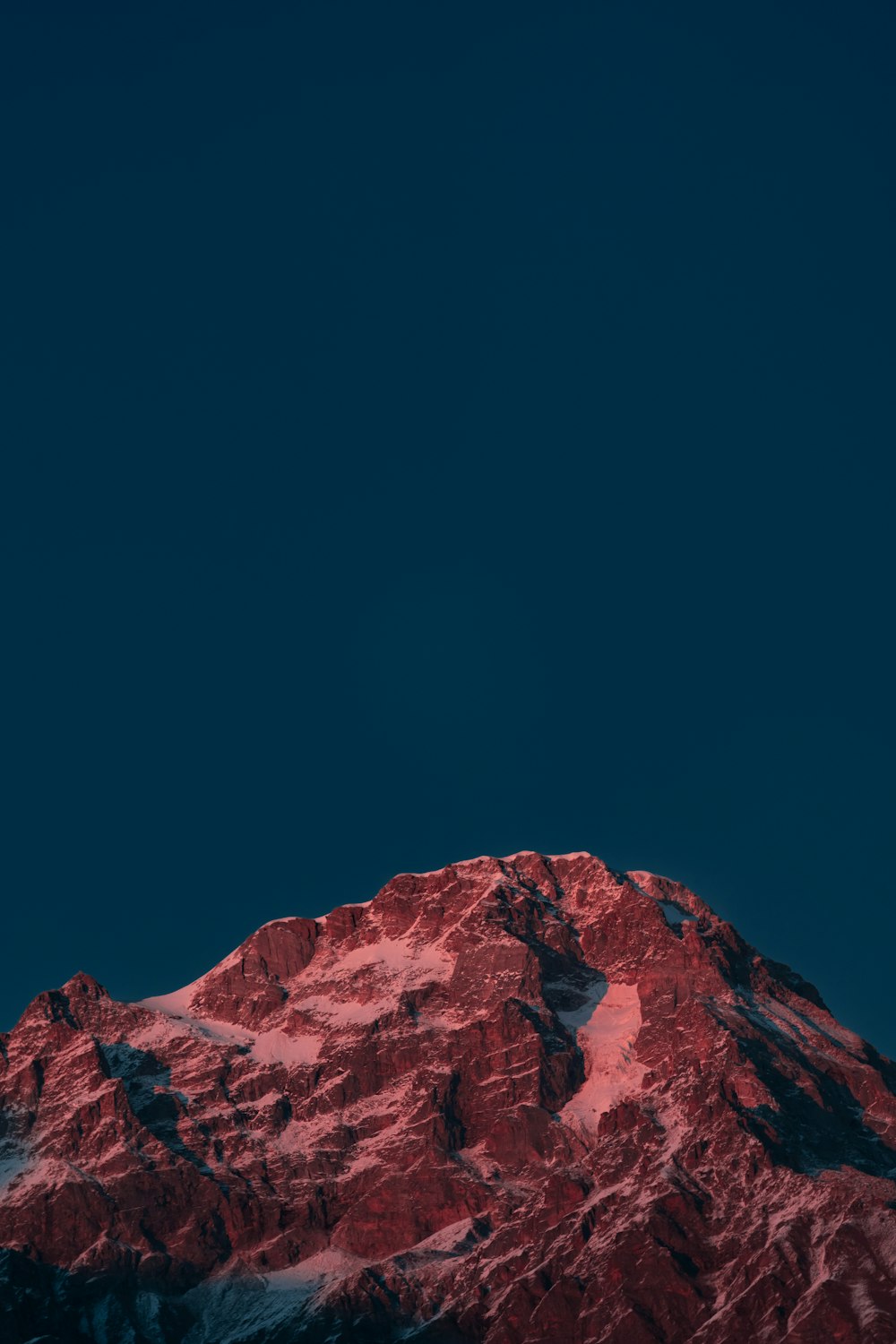 a plane flying in the sky over a snow covered mountain