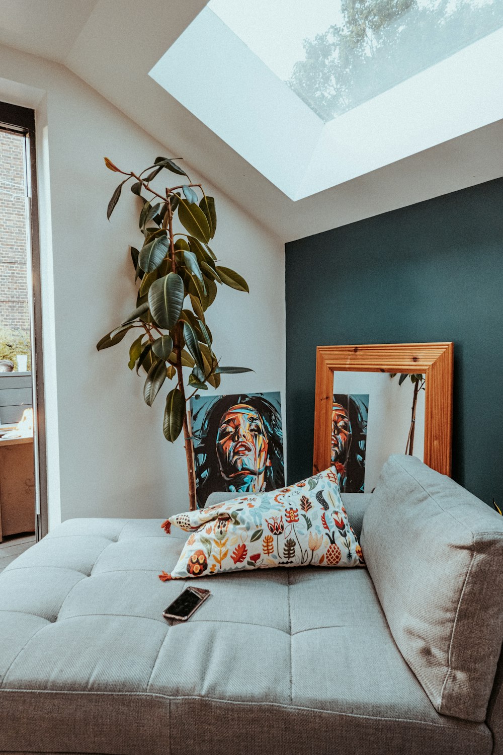 a living room with a couch and a potted plant