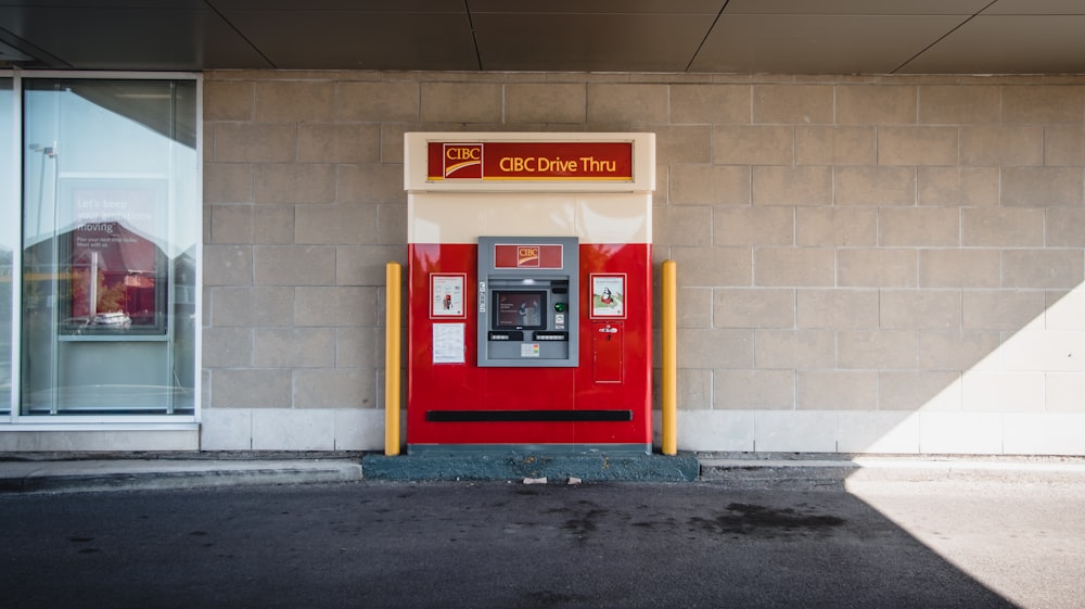 a red phone booth sitting next to a building