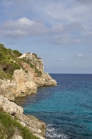 a large body of water next to a rocky cliff