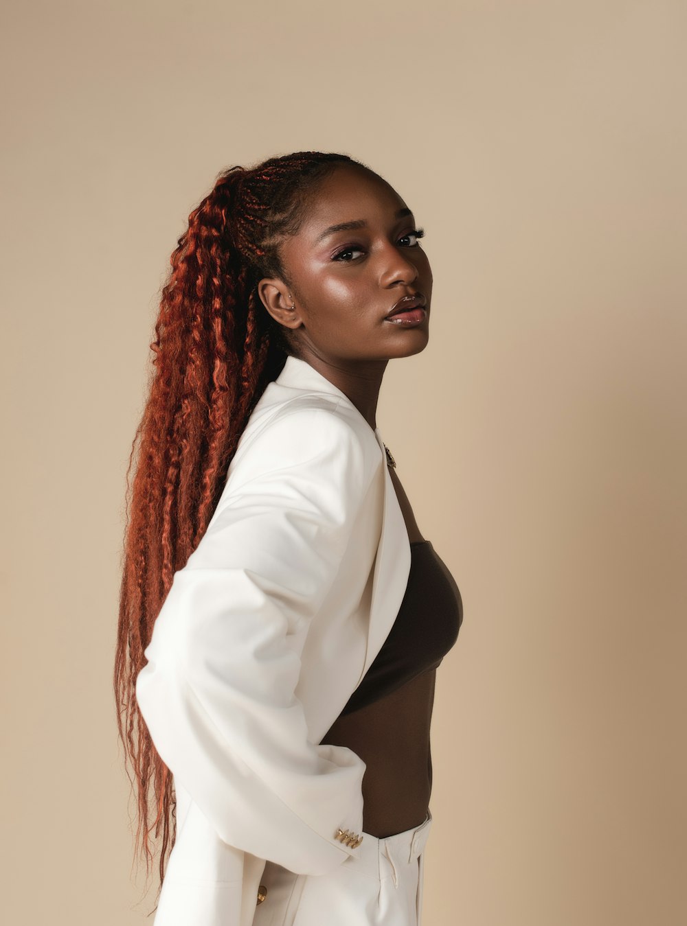 a woman with red hair wearing a white suit