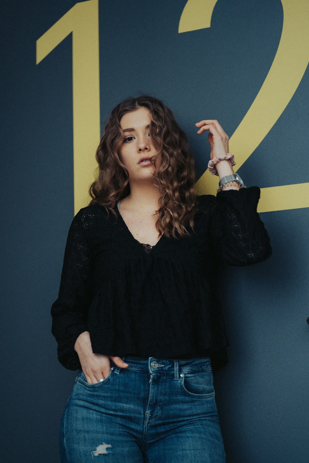 a woman standing in front of a blue wall