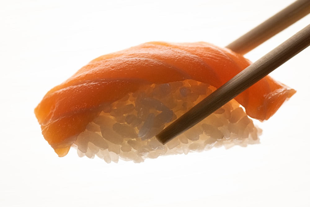sushi with chopsticks on a white surface
