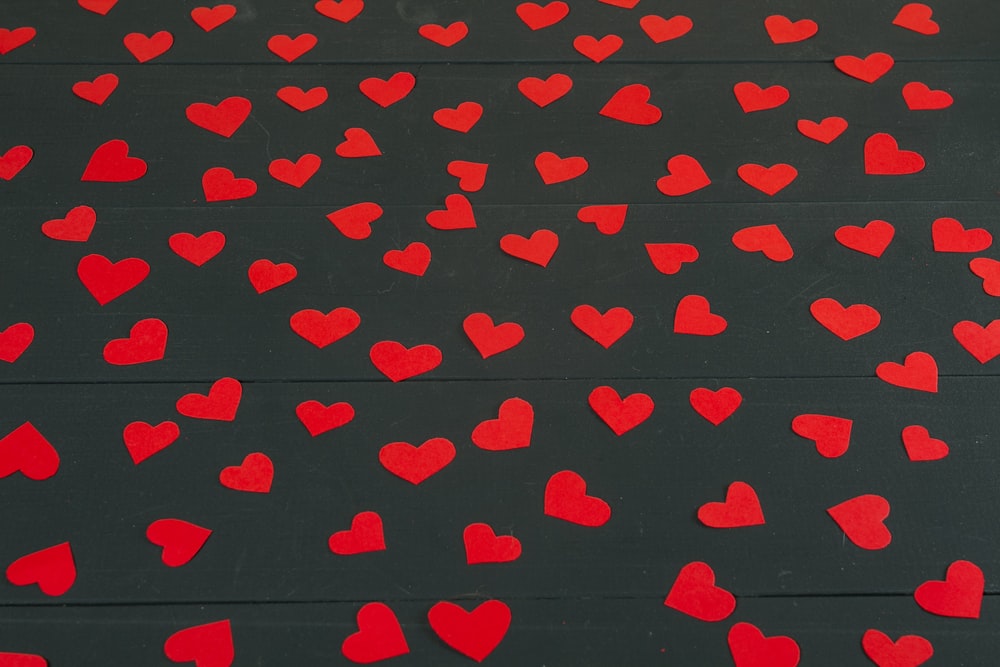 a bunch of red hearts on a black background