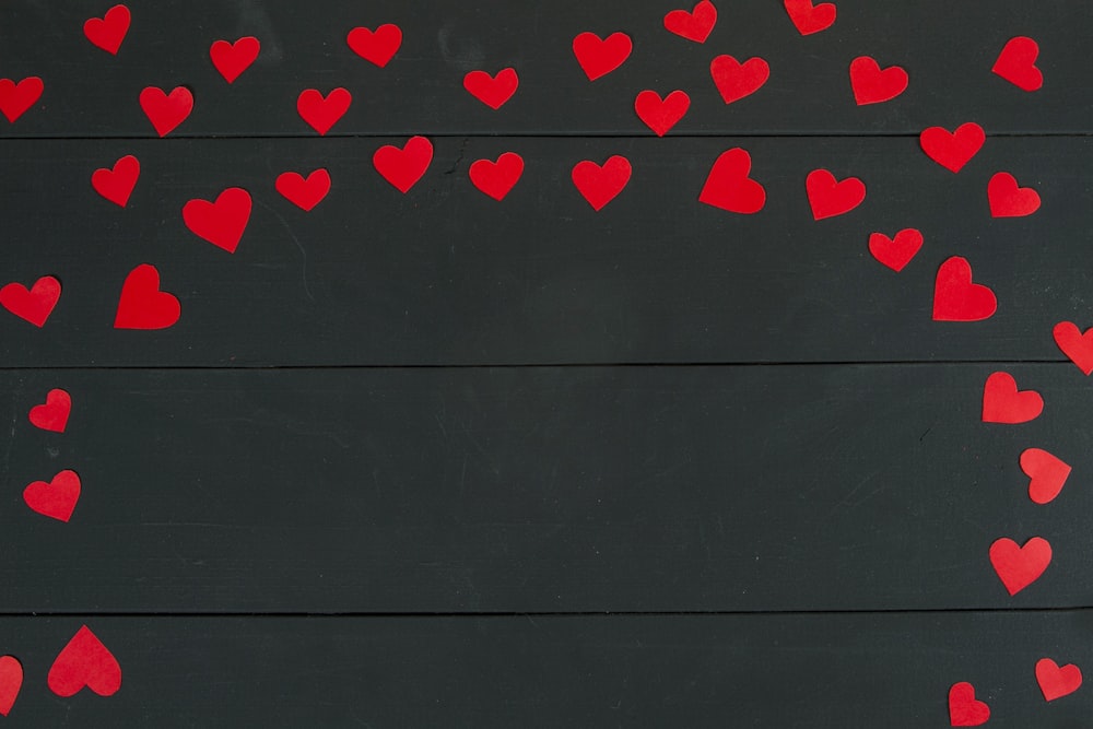 a bunch of red hearts on a black background