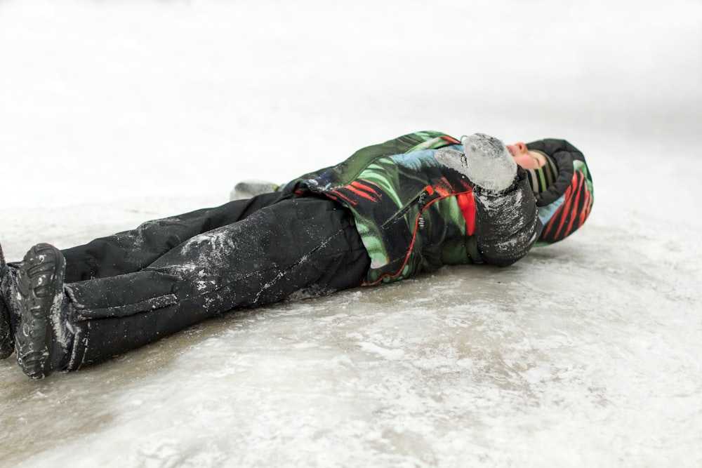 寒い日に氷の上に横たわる少年