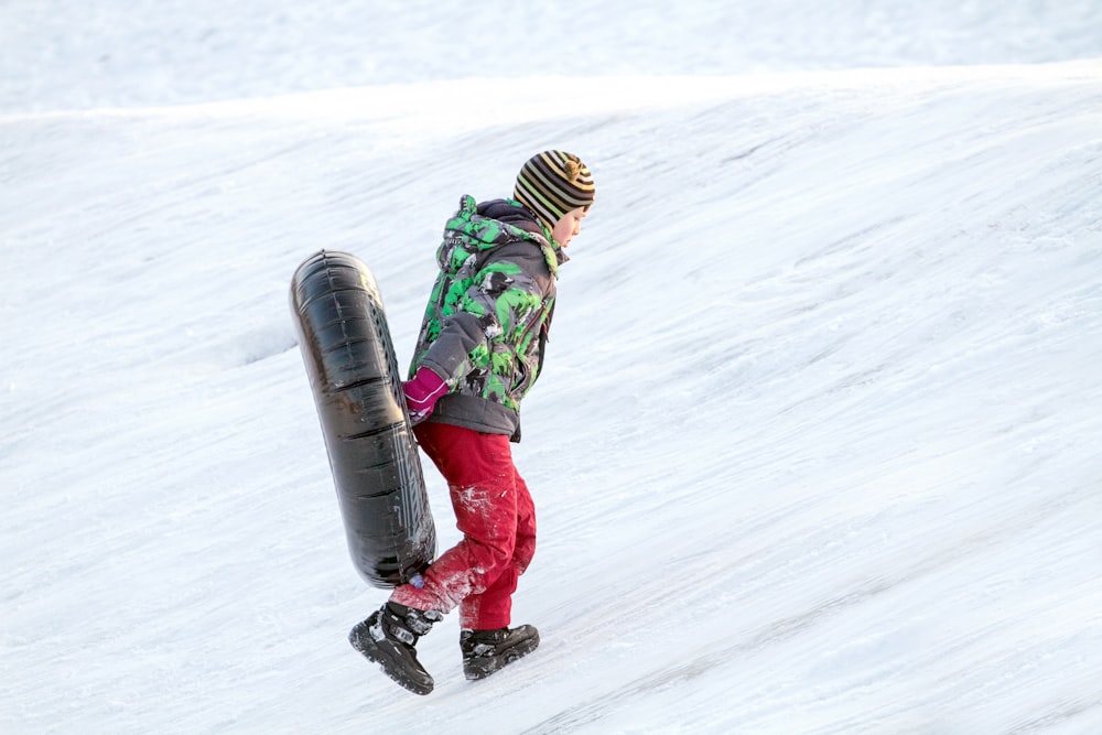 a person riding a snowboard down a snow covered slope