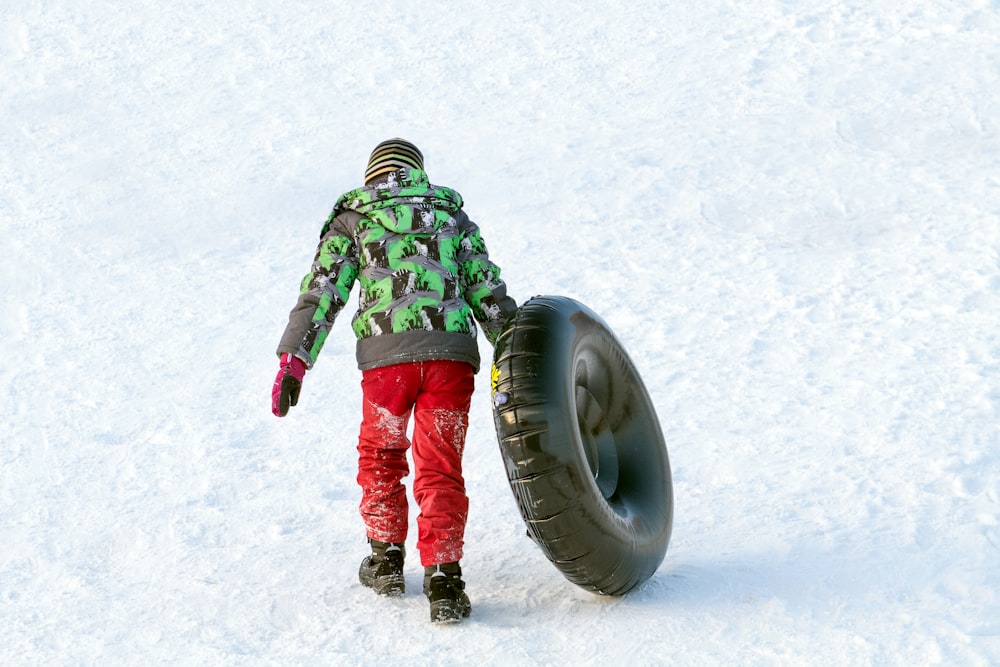 a person standing next to a tire in the snow