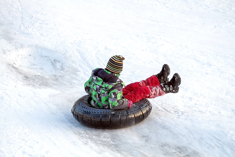 a person riding a tube down a snow covered slope