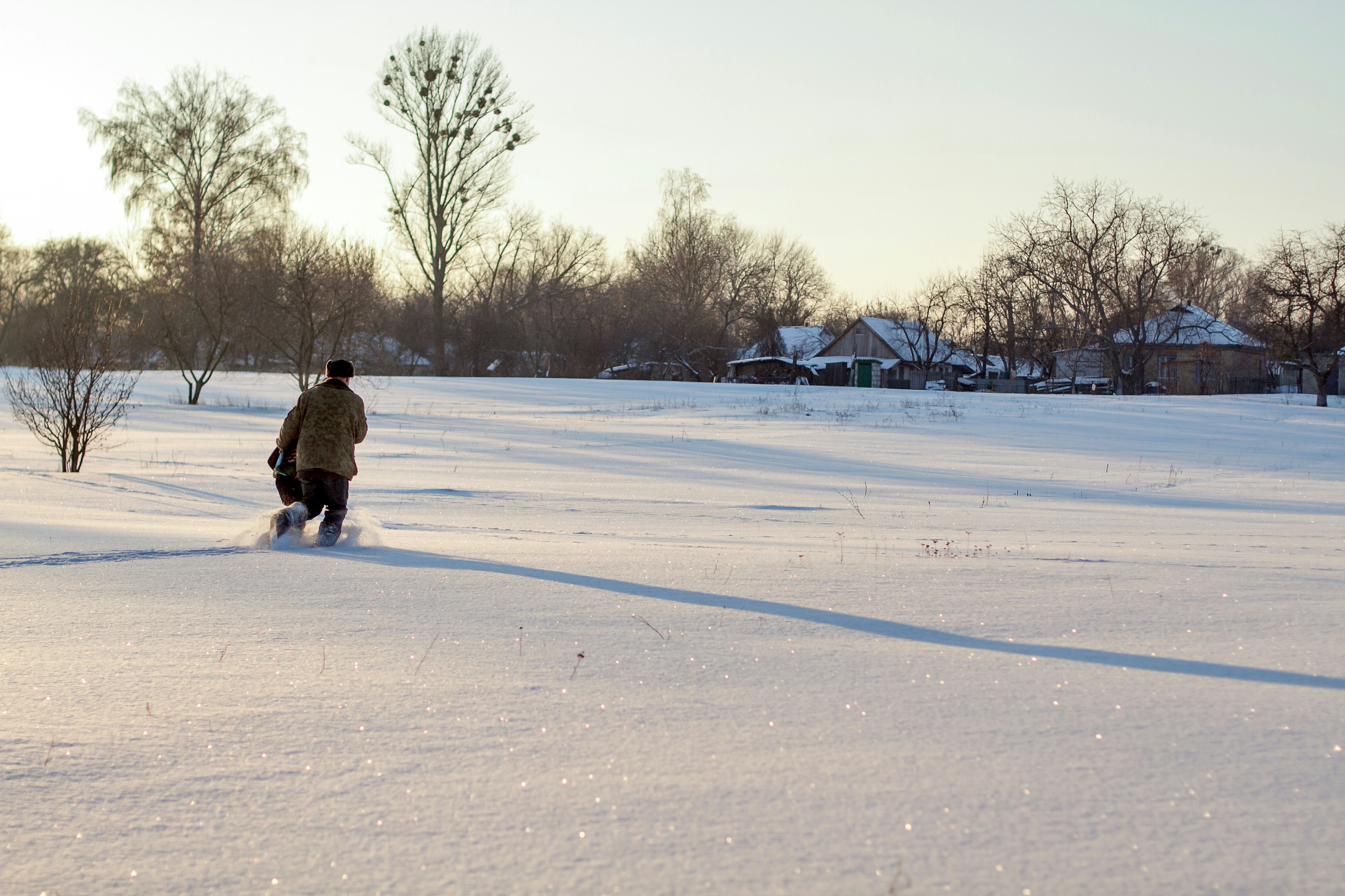 a man walking through a snow covered field