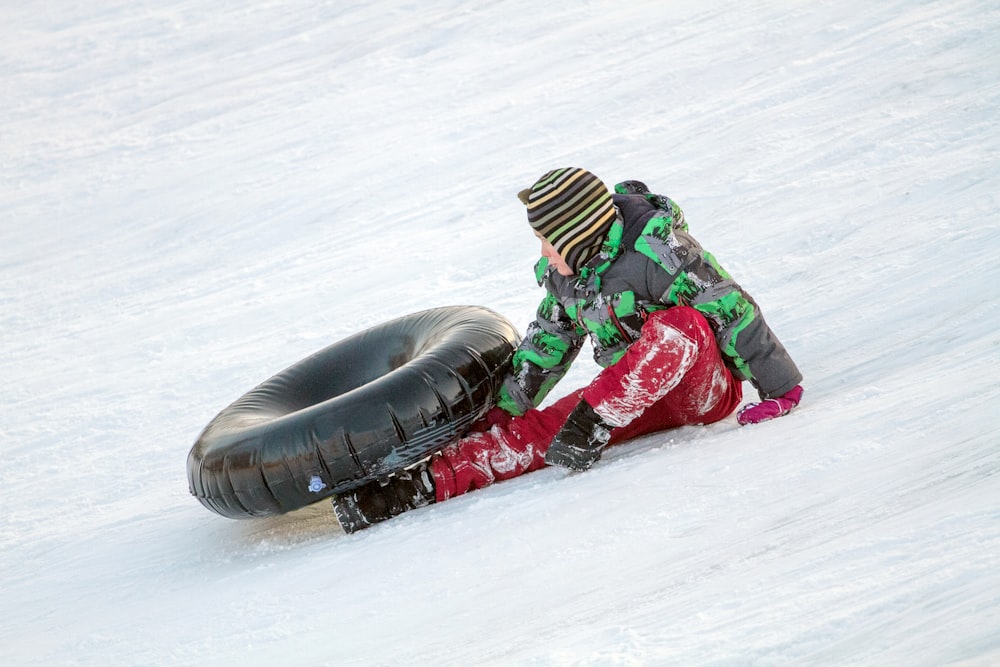 a person riding a snowboard down a snow covered slope