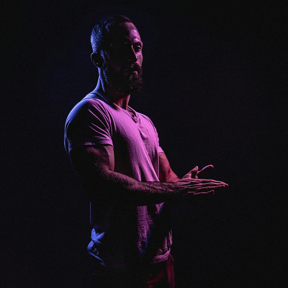 a man standing in the dark holding his hands open