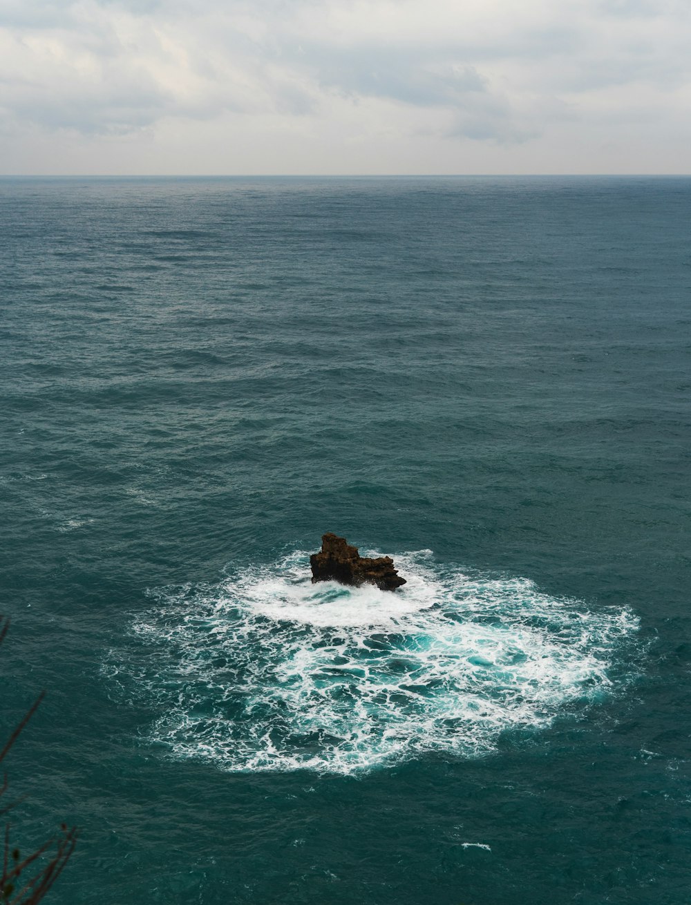 a large body of water with a rock in the middle of it