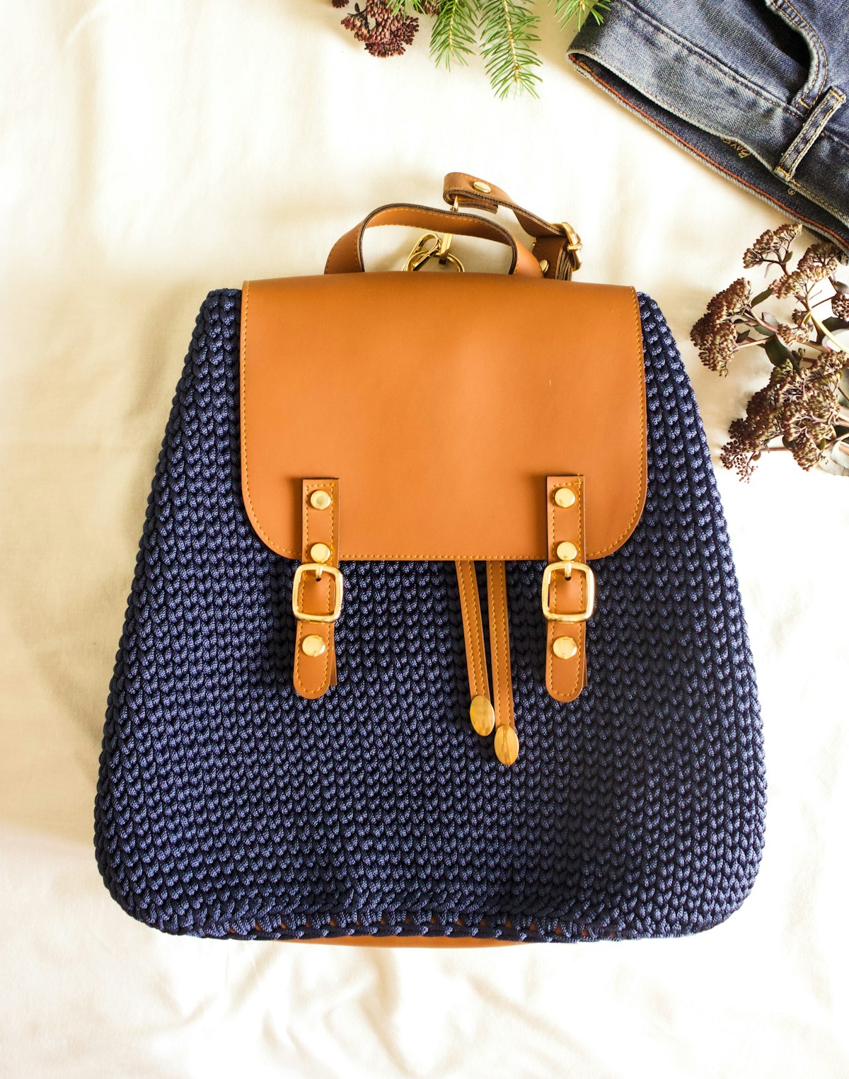Un sac à dos en maille bleu nuit à rabat de cuir cognac