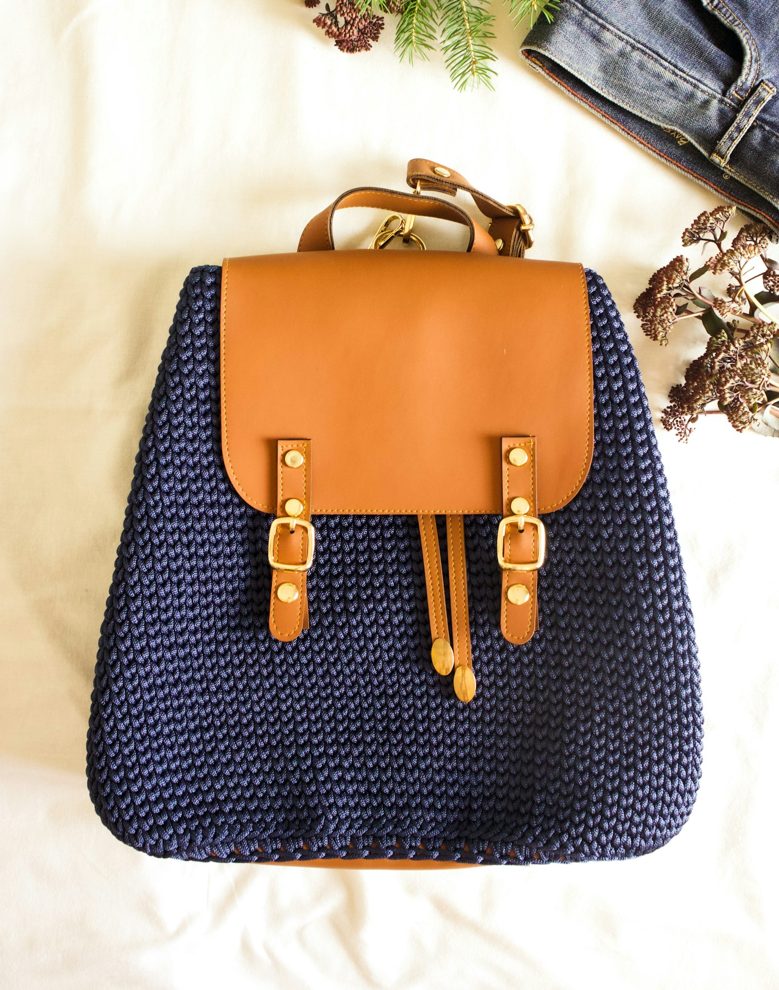 Un sac à dos en maille bleu nuit à rabat de cuir cognac