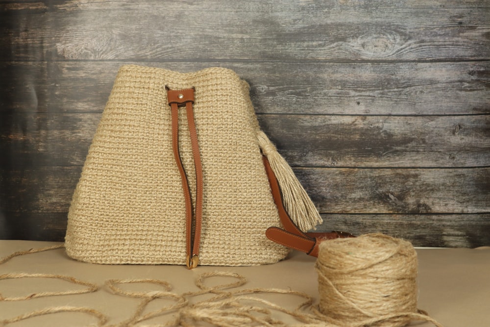 a bag sitting on top of a table next to a spool of twine