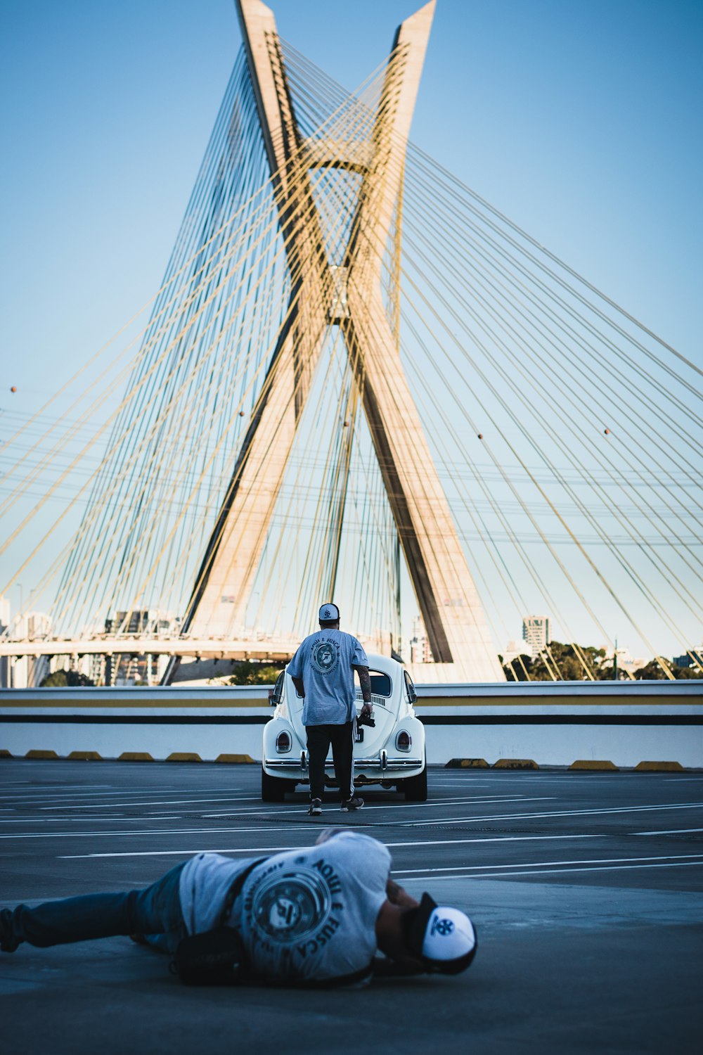 a man laying on the ground next to a car