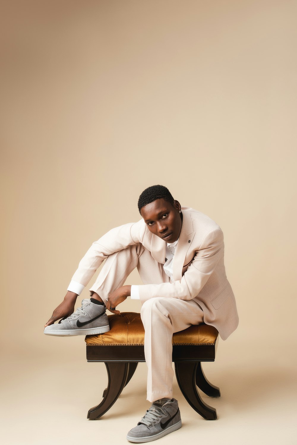 a man in a white suit sitting on a bench