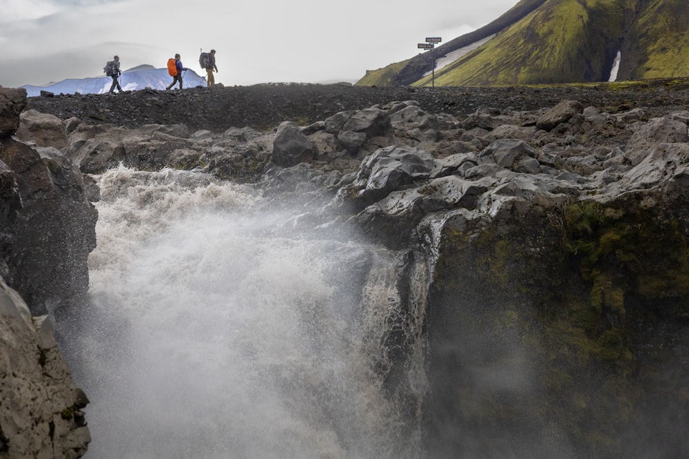 a group of people standing on top of a waterfall