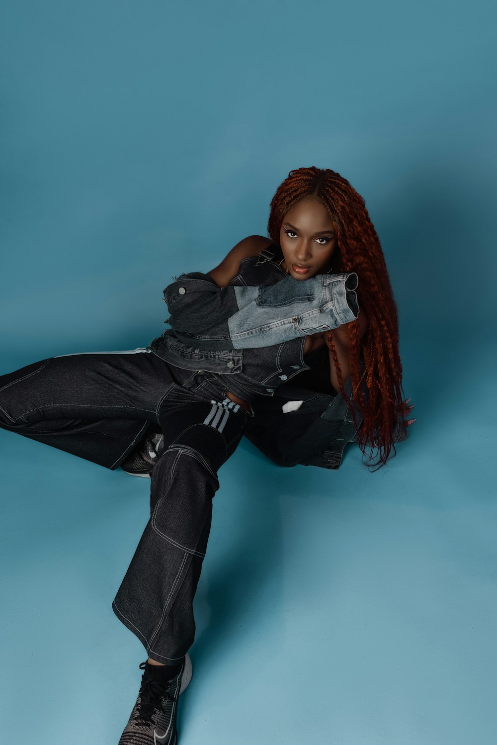 a woman with red hair sitting on a blue background