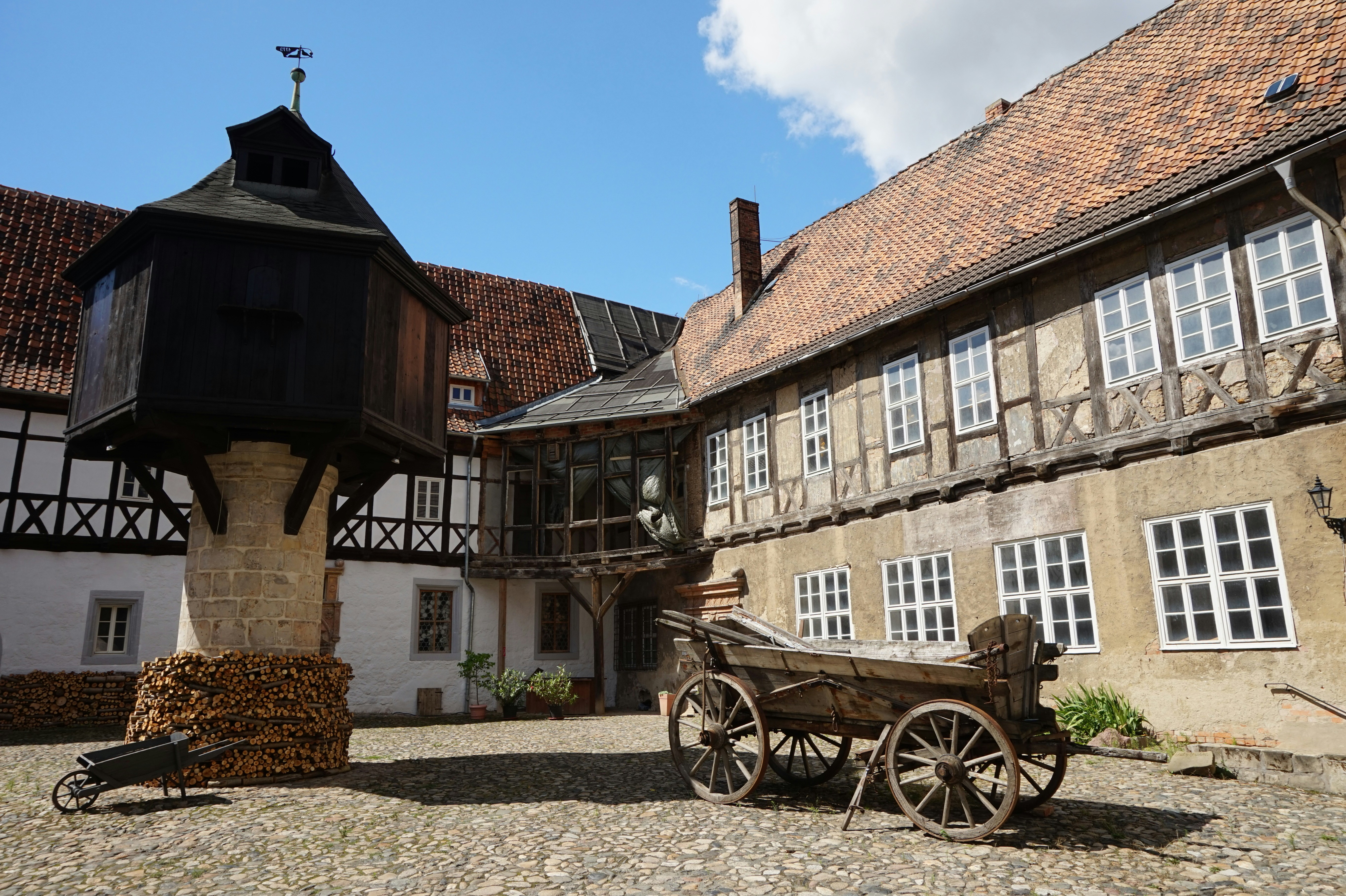a horse drawn carriage parked in front of a building, The meat yard in Quedlinburg, Germany
