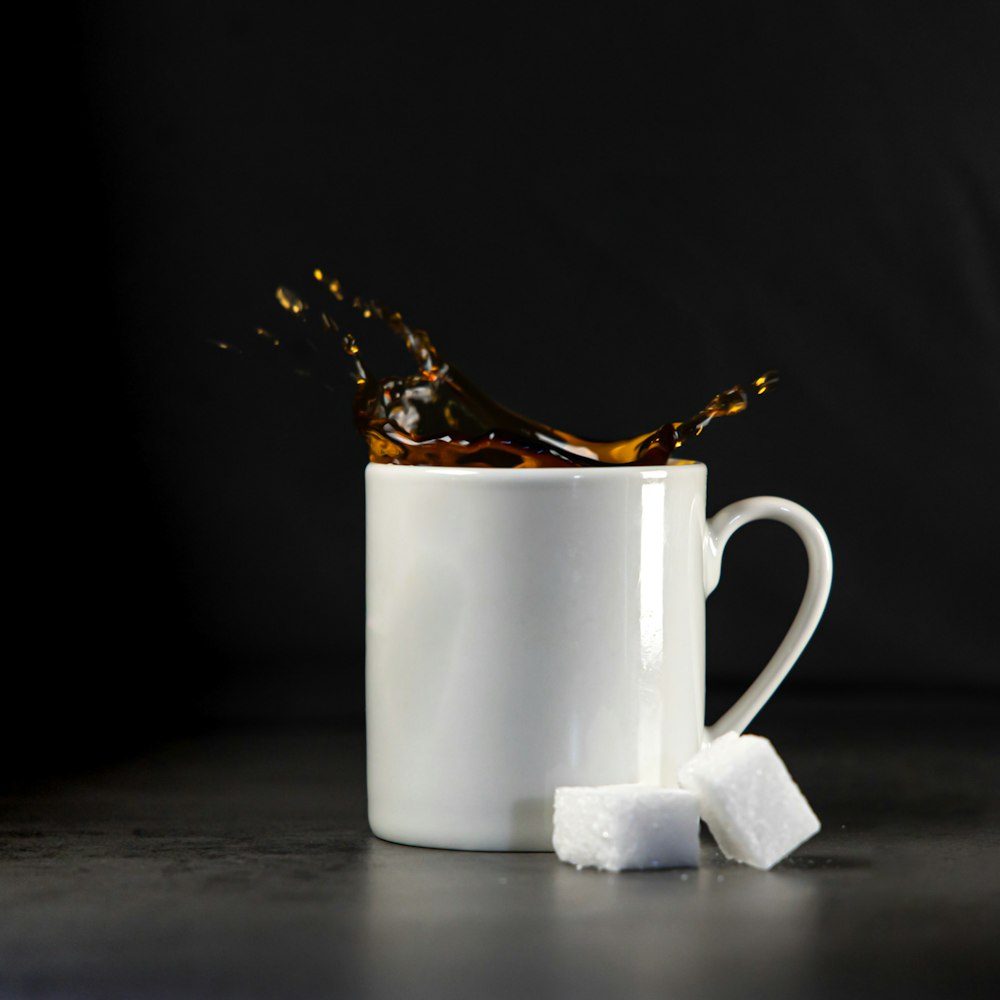 a white cup with some sugar cubes in it