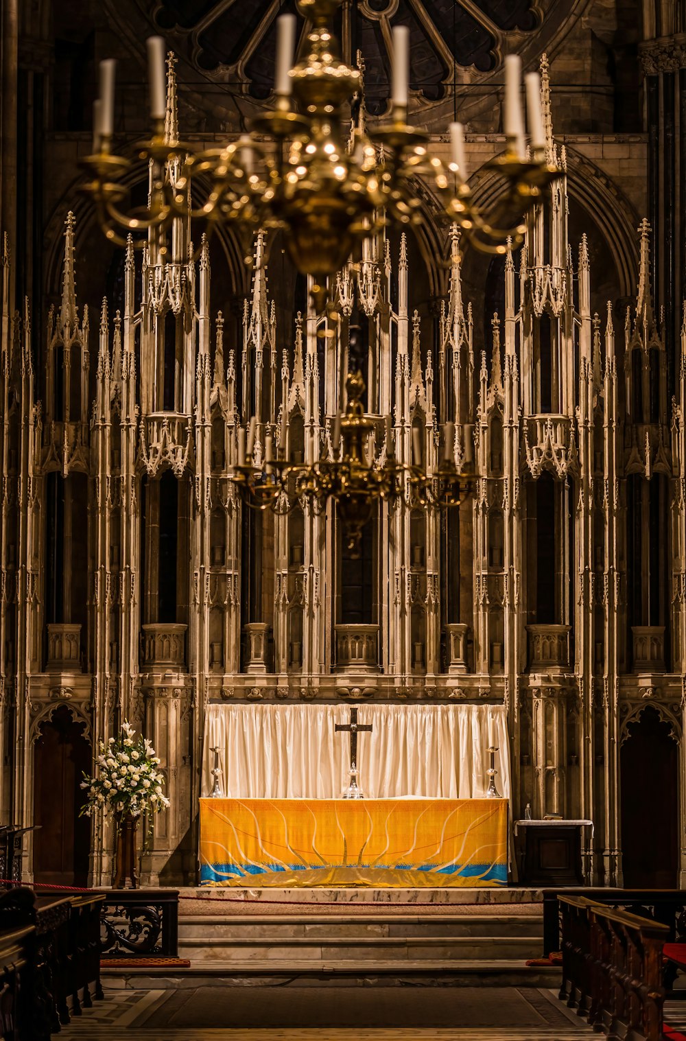 a church with a chandelier and a cross on the alter