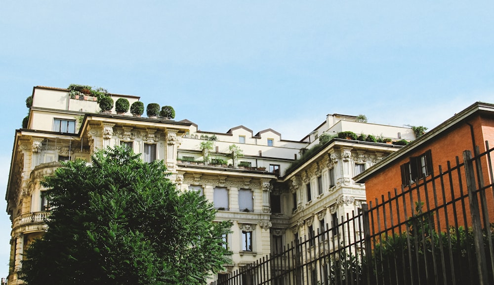 a tall building with lots of windows next to a fence