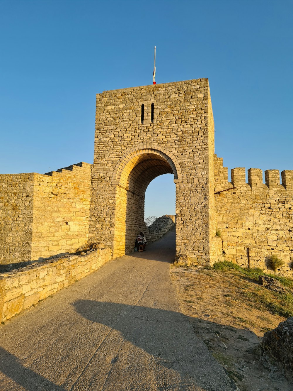 a car is parked in front of a stone gate