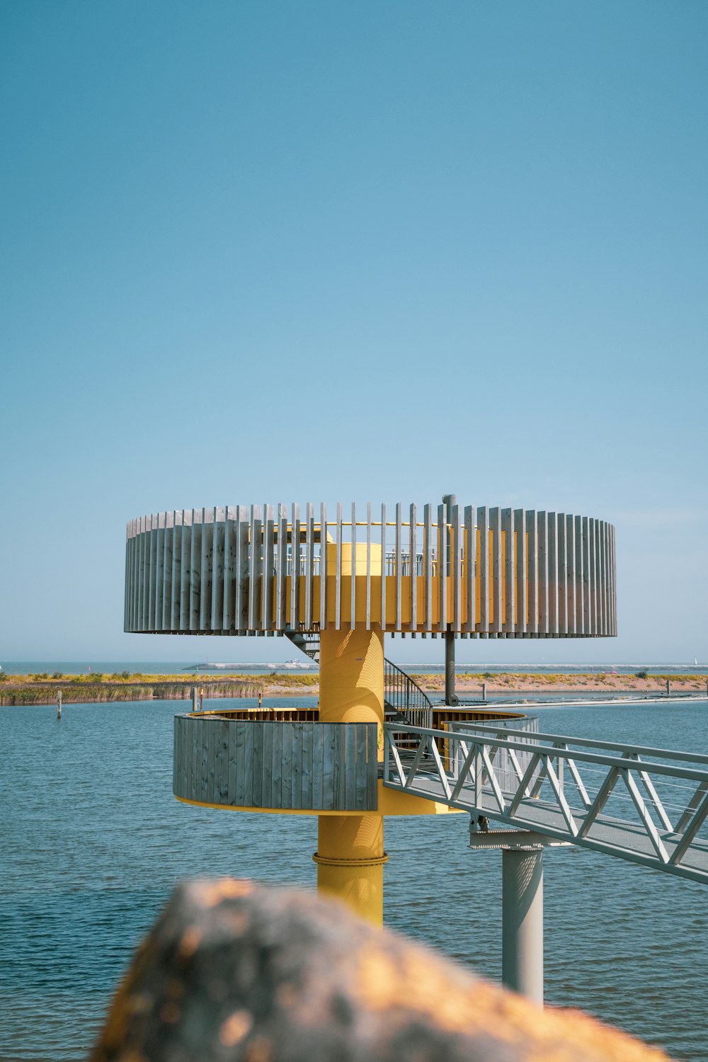 a yellow structure sitting on top of a body of water