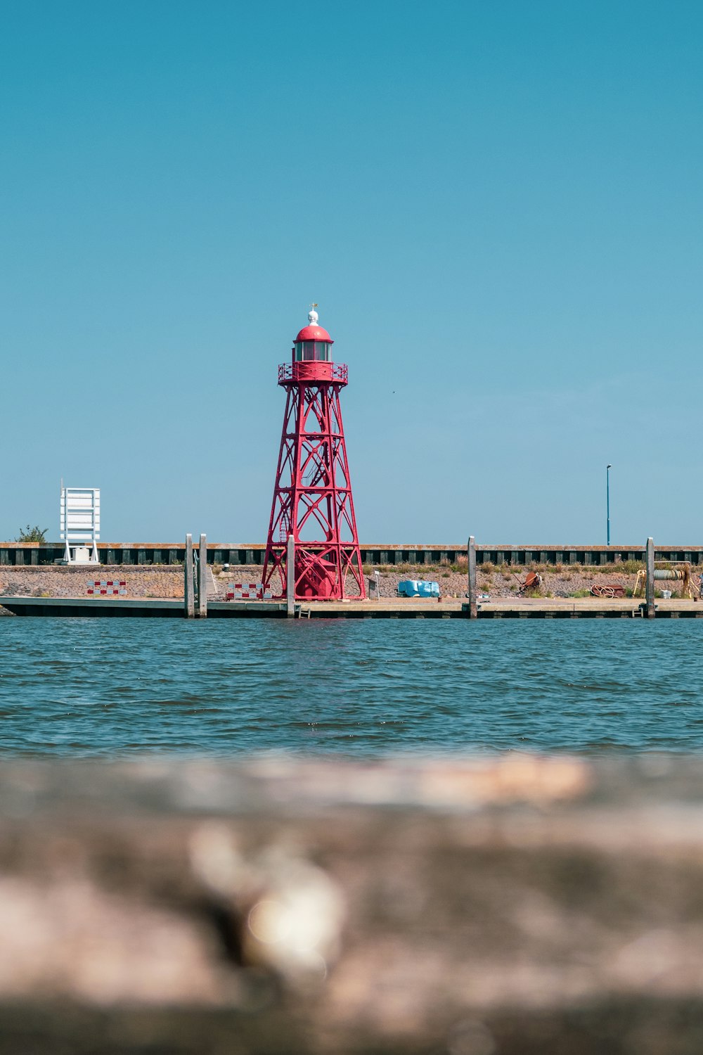a red light house sitting on top of a pier