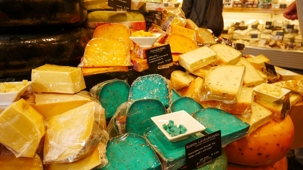 un présentoir dans un magasin rempli de nombreux types de fromages différents