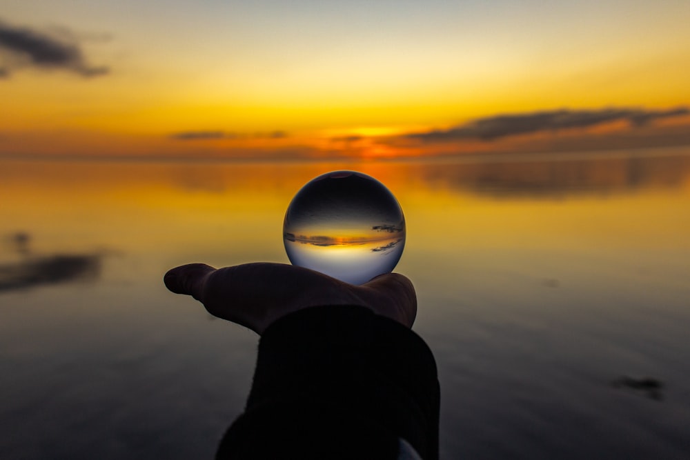 a person holding a glass ball in their hand