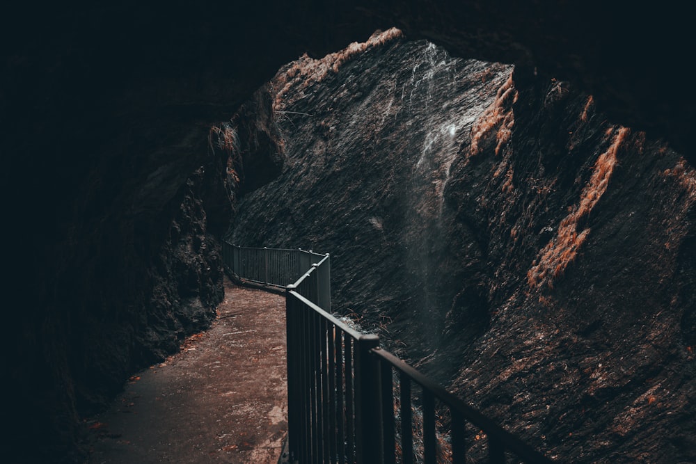 a walkway leading to a waterfall in a cave