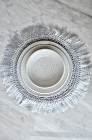 a white and silver plate on a marble table