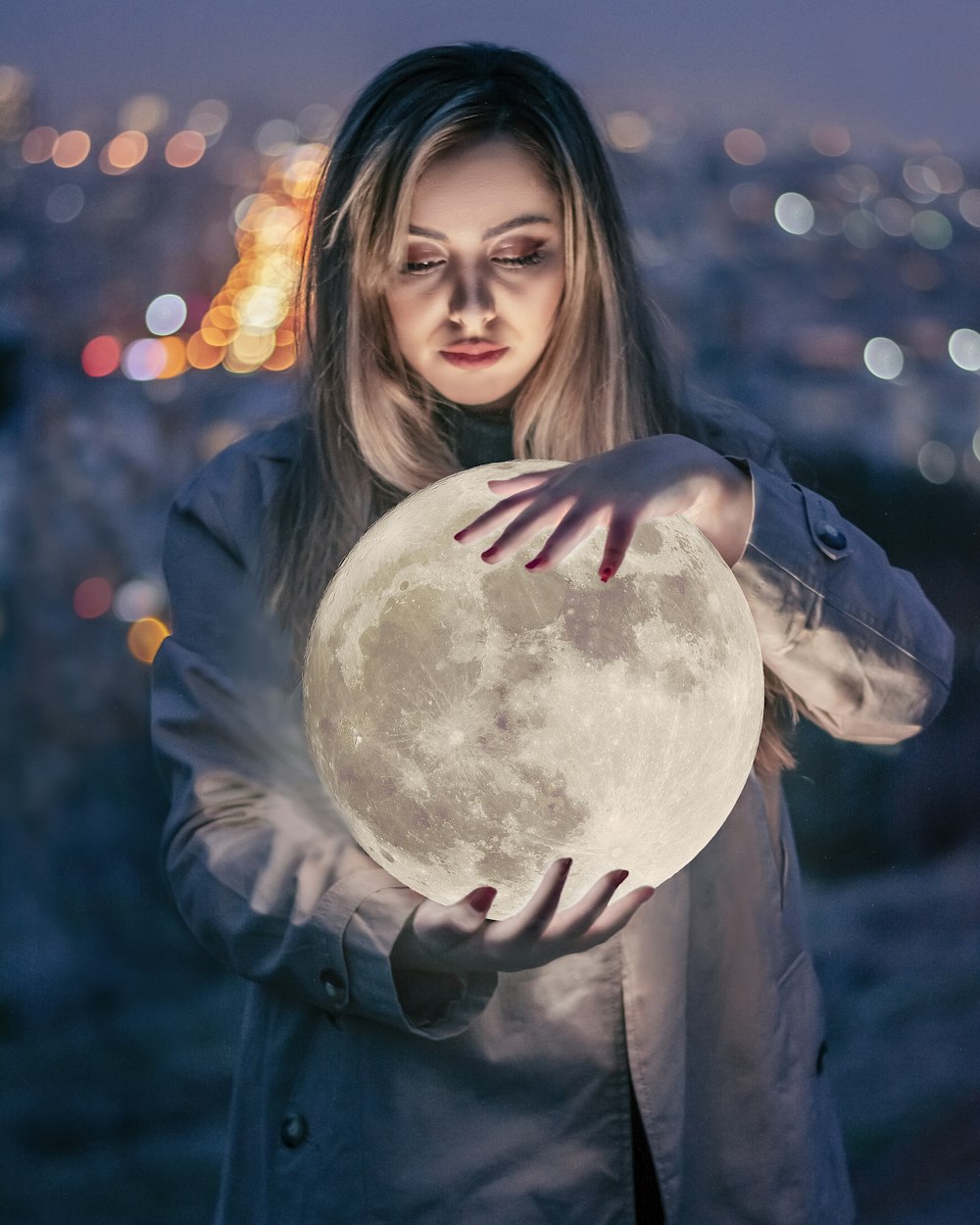 a woman holding a full moon in her hands
