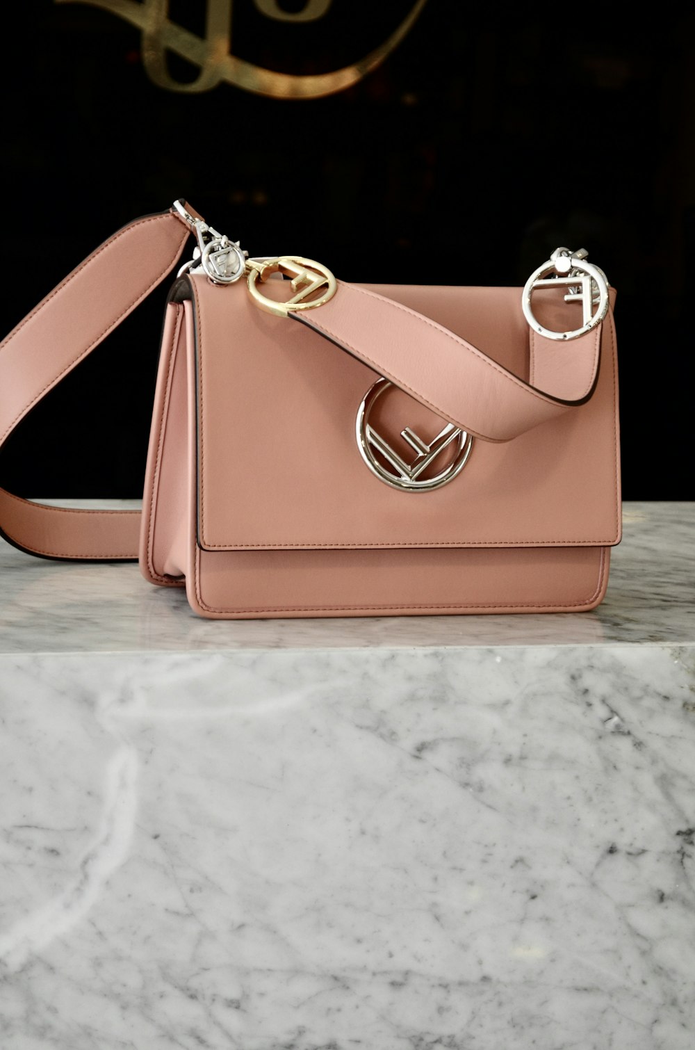 a pink purse sitting on top of a marble counter