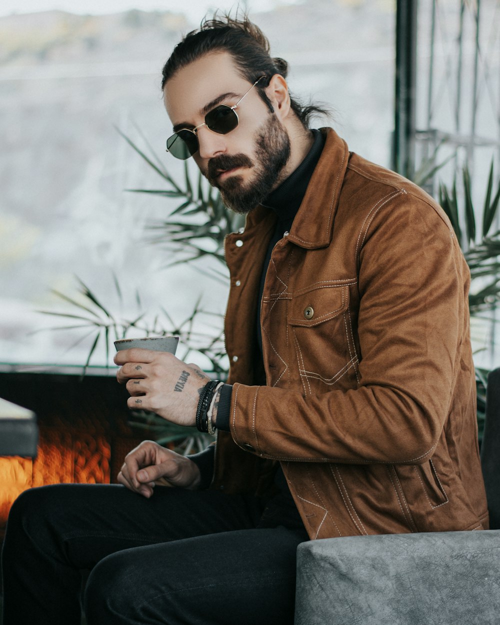 a man sitting on a couch with a cup of coffee