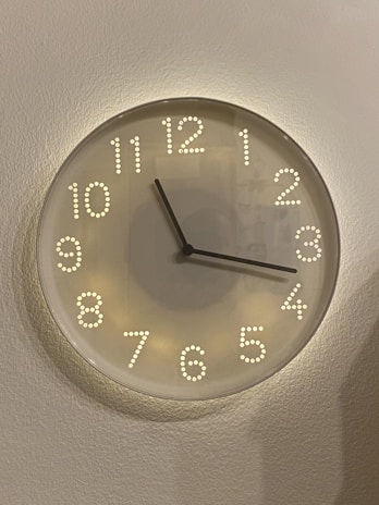 A sleek geometric wall clock made from layered acrylic, showcasing sharp laser-cut details.