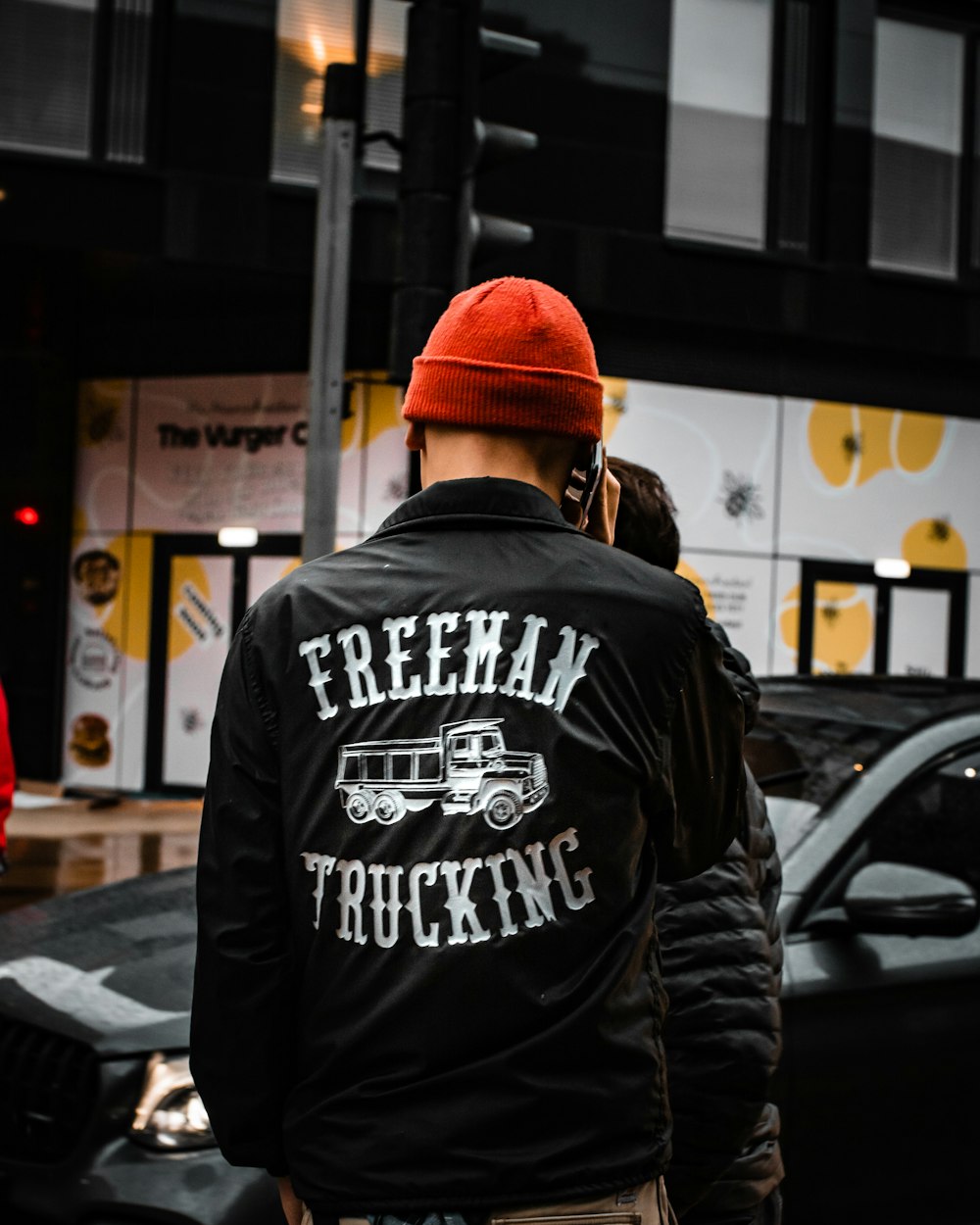 a man in a red hat is walking down the street