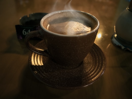 a steaming cup of coffee on a saucer
